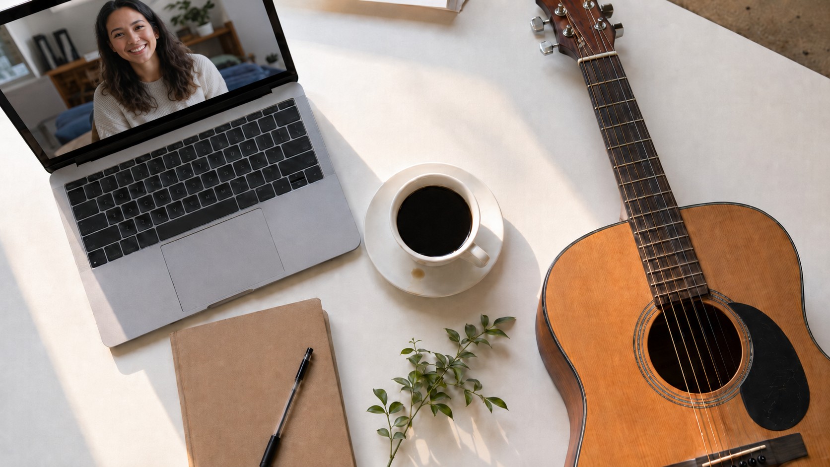 Morning music practice flatlay with coffee, guitar and a laptop video lesson